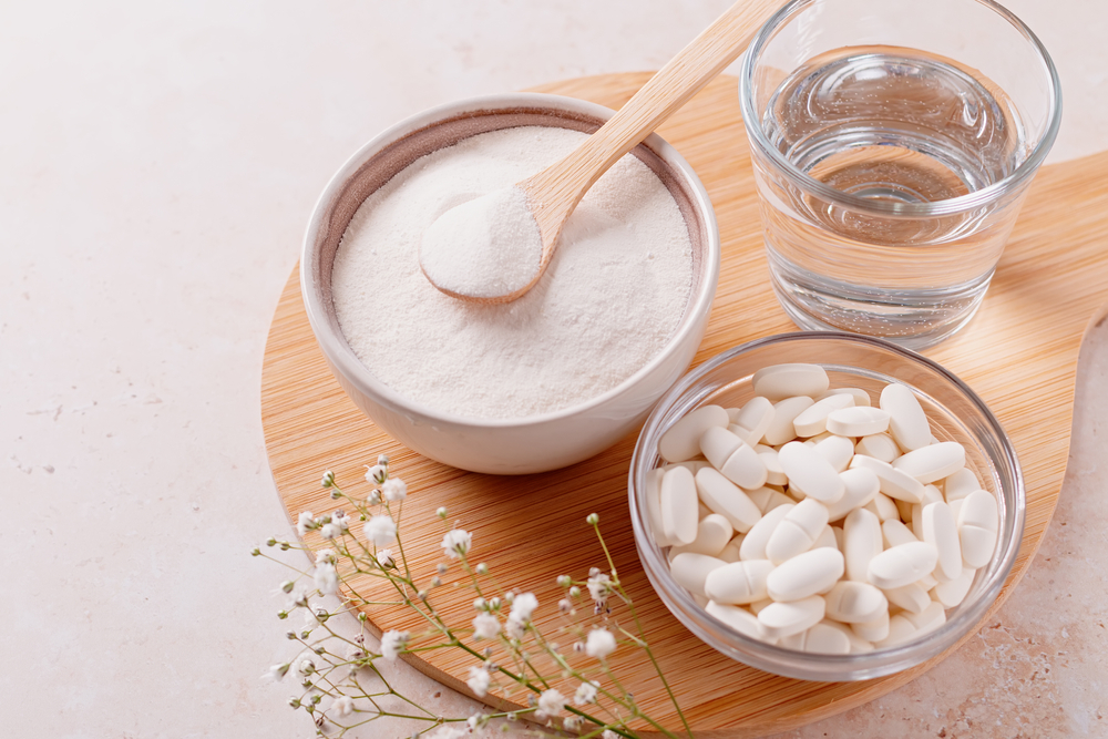 collagen powder and pills on a wooden tray